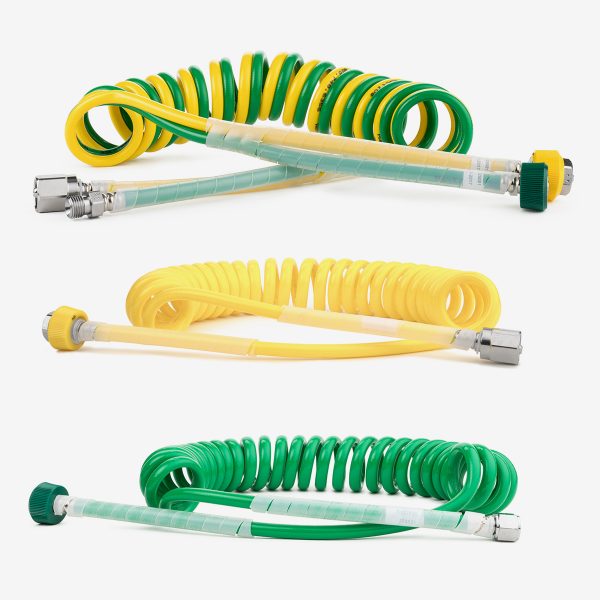 Three green and yellow air and oxygen coiled medical hoses on white background